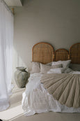 Shell Mattress Medium laying on bed next to ceramic vase and window