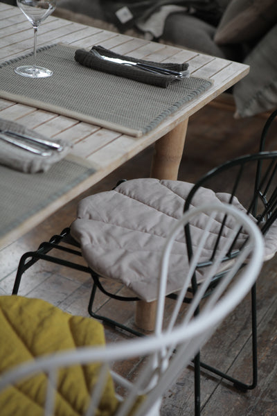 Small Shell Cushion in rescued fabric on steel chairs