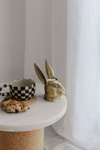 BUNNY Tealight Holder in brass on table with cup