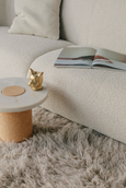 CAT Tealight Holder in brass on table with open book 