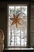 Winter Flower Lamp hanging in window next to Rattan furniture