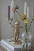 Chipmunk Candle Holder in Brass next to vase with flower
