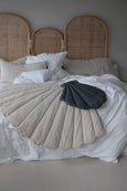 The Straw Small Shell Cushion on bed