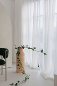 Rattan Vase in natural rattan with plants in front of white curtain