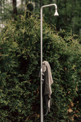 Thin Beach Blanket in organic fabric hanging on outdoor shower