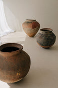 Vintage Pot Round shape standing on floor next to ceramic pots