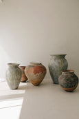 Vintage Pot Drop Shape standing next to ceramic pots in the sun